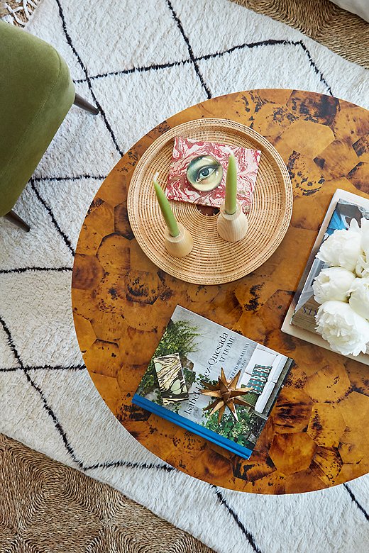 
The round penshell coffee table anchors the room and adds warmth and texture to the space, Samantha says. “I’m constantly changing out the objets, candles, and coffee table books I’m displaying, depending on my mood and the season.”

